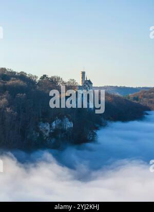 Sonnenschein in den Bergen, Nebel im Echaztal. Schloss Lichtenstein auf der Schwäbische Alb. Das Märchenschloss Württembergs ist ein im Stil des Histo Stockfoto