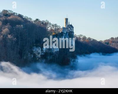 Sonnenschein in den Bergen, Nebel im Echaztal. Schloss Lichtenstein auf der Schwäbische Alb. Das Märchenschloss Württembergs ist ein im Stil des Histo Stockfoto