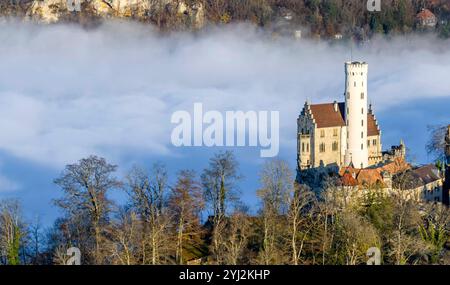 Sonnenschein in den Bergen, Nebel im Echaztal. Schloss Lichtenstein auf der Schwäbische Alb. Das Märchenschloss Württembergs ist ein im Stil des Histo Stockfoto