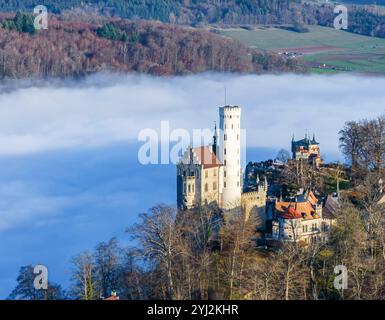 Sonnenschein in den Bergen, Nebel im Echaztal. Schloss Lichtenstein auf der Schwäbische Alb. Das Märchenschloss Württembergs ist ein im Stil des Histo Stockfoto