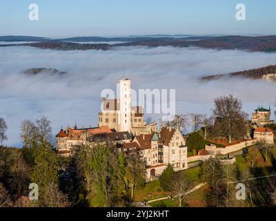 Sonnenschein in den Bergen, Nebel im Echaztal. Schloss Lichtenstein auf der Schwäbische Alb. Das Märchenschloss Württembergs ist ein im Stil des Histo Stockfoto