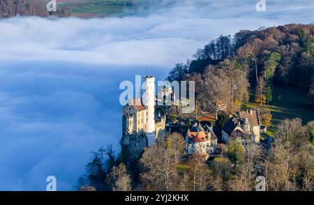 Sonnenschein in den Bergen, Nebel im Echaztal. Schloss Lichtenstein auf der Schwäbische Alb. Das Märchenschloss Württembergs ist ein im Stil des Histo Stockfoto