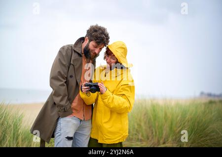 Ein paar Rezensionen Fotos auf einer Kamera zusammen am Strand an einem bewölkten Tag, Belgien Stockfoto