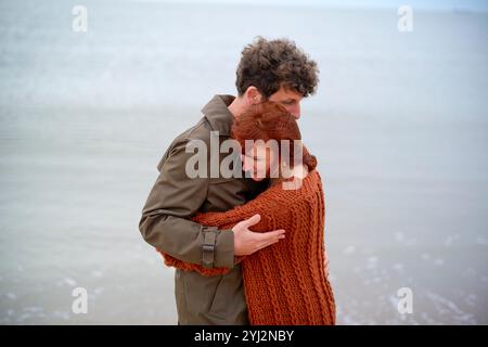 Paare umarmen sich liebevoll an einem nebeligen Strand, Belgien Stockfoto