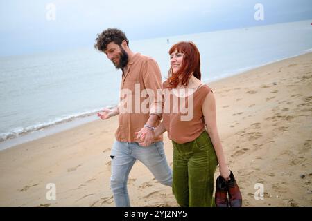 Ein lächelndes Paar spaziert Hand in Hand an einem bewölkten Tag, Belgien Stockfoto