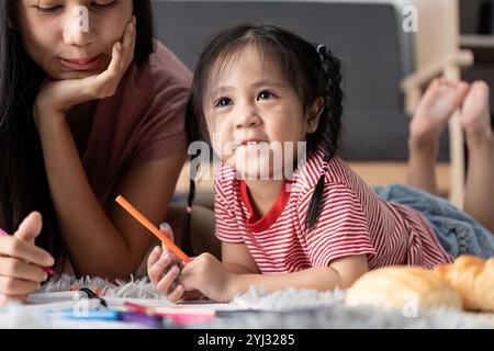 Junge Kinder, die gemeinsam mit Eltern zu Hause Lernaktivitäten durchführen, um Kreativität und Bildung in einer angenehmen Umgebung zu fördern Stockfoto