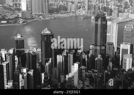 Wolkenkratzer umgeben die Victoria Bay und zeigen das geschäftige Wasserleben und das Stadtleben in Hongkong bei hellem Tageslicht. Stockfoto