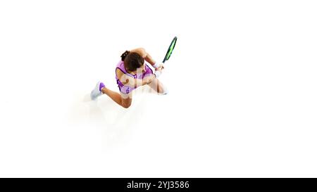 Fokussierte Tennisspielerin im Top-Down-Shot, ihre Augen fixiert auf dem Ball vor weißem Studiohintergrund. Stockfoto