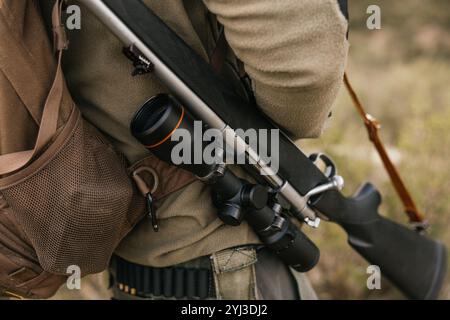 Hunter trägt Khaki und trägt Jagdgewehr auf der Schulter Stockfoto