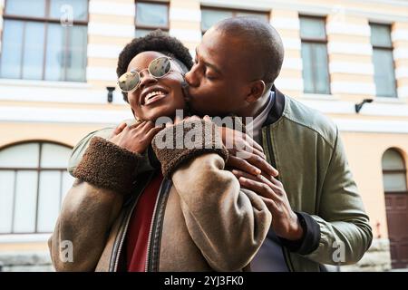 Warm Urban Pärchen teilt einen fröhlichen und liebevollen Moment an einem hellen Tag Stockfoto