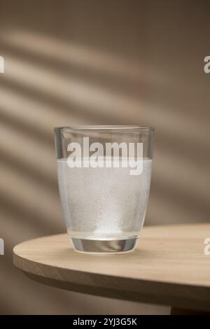 Eine brausende Mukolytika-Tablette löst sich in einem Glas Trinkwasser auf und zeigt ihre schnelle Wirkung beim Abbau von Schleim für eine leichtere Atmungsaktivität Stockfoto