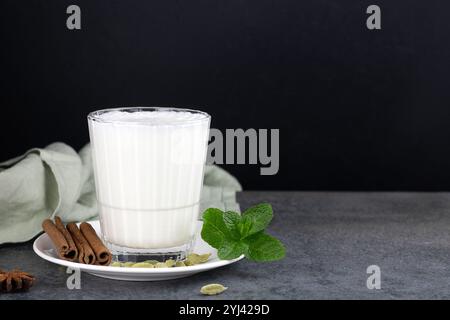 Beliebtes indisches kaltes Getränk - Lassi. Joghurtgetränk mit Gewürzen und Minze auf schwarzem Hintergrund. Indisches Essen. Kopierbereich. Stockfoto