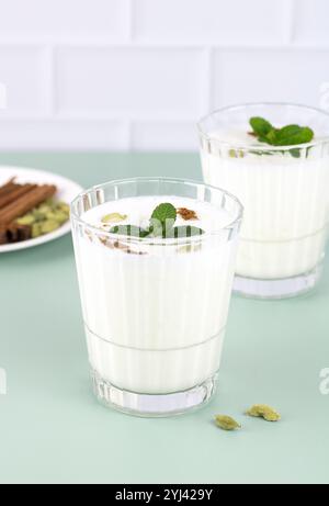 Indisches kaltes Getränk auf Basis von Dahi-Joghurt, Milch und Gewürzen - Lassi auf grünem Hintergrund. Kopierbereich. Stockfoto