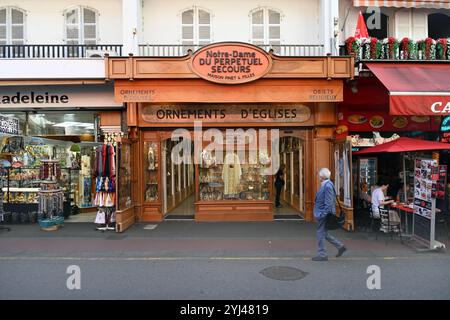 Man läuft an einem religiösen Kleiderladen, einem Kirchenladen oder einem christlichen Souvenirladen in Lourdes Hautes-Pyrénées Frankreich vorbei Stockfoto