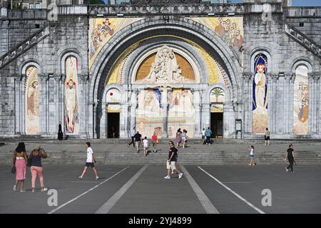 Touristen, Pilger und geschmückte Fassade der Basilika unserer Lieben Frau vom Rosenkranz, oder Rosenkranz Basilca, und Rosenkranzplatz, Lourdes Hautes-Pyrénées Frankreich Stockfoto