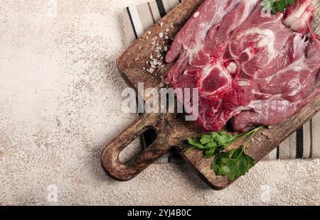 Rohes Steak, Kalbshals auf dem Knochen, frisches Fleisch, auf einem Schneidebrett, mit Gewürzen, Blick von oben, ohne Leute Stockfoto