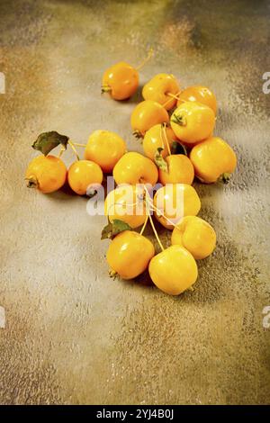 Gelbe kleine Äpfel, chinesische Vielfalt, verstreut auf dem Tisch, Blick von oben, keine Leute Stockfoto