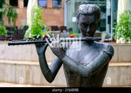 Skulptur eines Flötisten, der vor der Joseph Elsner Philharmonie (Filharmonia Opolska) in Opole, Woiwodschaft Opole, Polen, musiziert. Stockfoto