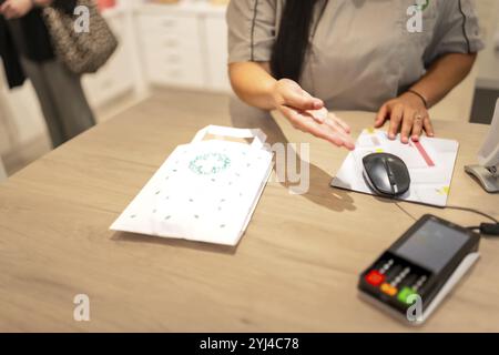 Zugeschnittenes Foto eines Apothekers, der angibt, wie man am Apothekenschalter bezahlt Stockfoto