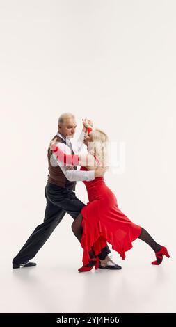 Tangoästhetik durch Jahre. Ältere schöne Frau und hübscher älterer Mann, Paar tanzt Tango isoliert auf weißem Hintergrund. Stockfoto
