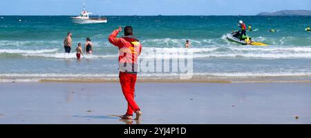 Ein Panoramabild der Rettungsschwimmer der RNLI Royal National Lifeboat Institution, die am Towan Beach in Newquay in Cornwall in Großbritannien zusammenarbeiten. Stockfoto