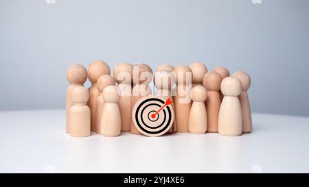 Holzpuppen, die um Dartbrett stehen, um Geschäftsziele zu schaffen und zu erreichen. Zielkonzept von Geschäft und Personal in einem Unternehmen. Marketi Stockfoto