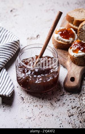 Zwiebelmarmelade auf Toast mit Frischkäse, grauer Hintergrund. Stockfoto