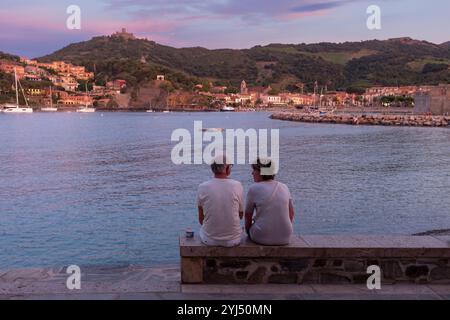 Paare, die miteinander reden, sitzen auf Steinbank, Collioure, Pyrenäen Orientales, Roussillon, Occitanie, Frankreich, Europa Stockfoto