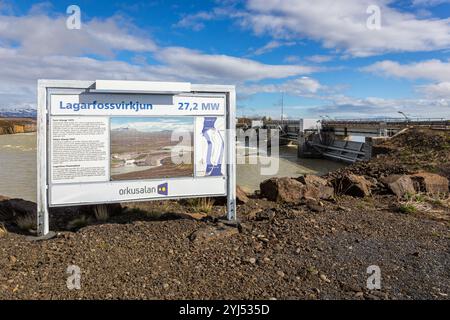 Lagarfossvirkjun, Island, 19.05.22. Staudamm des Wasserkraftwerks Lagarfossvirkjun am Fluss Lagarfljot, Island mit Informationsschild. Braunes Gletscherwasser. Stockfoto