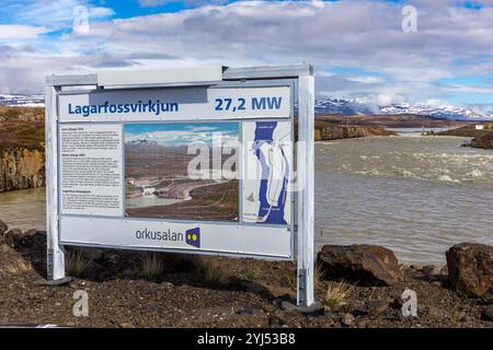 Lagarfossvirkjun, Island, 19.05.22. Staudamm des Wasserkraftwerks Lagarfossvirkjun am Fluss Lagarfljot, Island mit Informationsschild. Braunes Gletscherwasser. Stockfoto