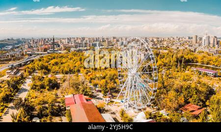 Jerewan, Armenien - 19. oktober 2024: Riesenrad mit Panoramablick aus der Luft im Victory Park mit Stadtbild und Gebäuden von Jerewan. Sonniger Herbsttag ca. Stockfoto