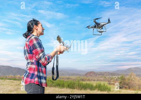 Eine junge Frau kontrolliert eine Drohne. Stockfoto