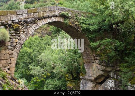 Eine sehr gut erhaltene Bogenbrücke im römischen Stil über einen Fluss. Misarela-Brücke, Gerês Portugal. Stockfoto