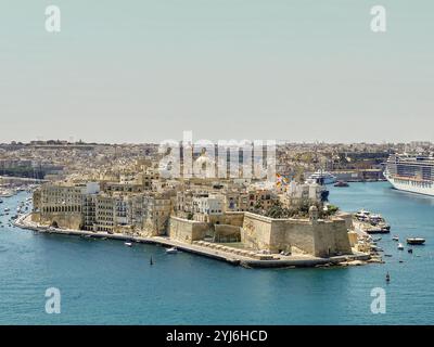 Blick aus der Vogelperspektive auf Sengleas historische befestigte Stadt, umgeben vom blauen Wasser des Grand Harbour, mit Schiffen und Yachten in der Nähe. Stockfoto