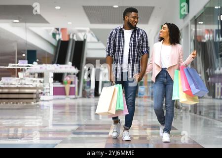 Einkaufen Für Die Ganze Familie. Glückliches Afroamerikanisches Paar, Das Im Kaufhaus Spaziert, Zusammen Einkäufe Tätigt, Saisonale Verkäufe Und Rabatte Genießt, Black Sp Stockfoto