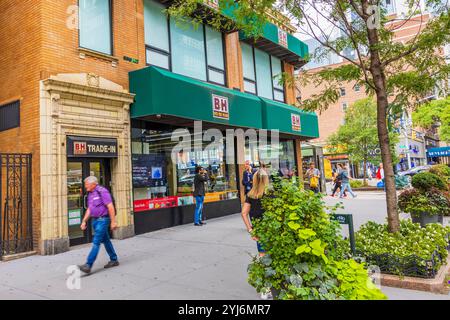 Blick auf die Straße des BH Photo Video Stores mit Leuten, die vorbeilaufen, und grüne Ladenfront in New York City. New York. USA. Stockfoto