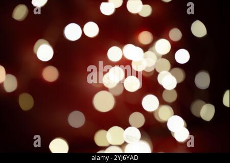 Ein unscharfes Bild mit einem roten Hintergrund mit vielen weißen Kreisen. Die Kreise sind unterschiedlich groß und im gesamten Bild verstreut. Die Szene ist eine von Chaos und Verwirrung Stockfoto