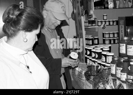 Kaukasisches Seniorenpaar im Alter von 60 bis 65 Jahren stöbern auf dem WNC Farmers Market in Asheville, North Carolina, USA, in Gläsern mit Gelee und Marmelade. Stockfoto