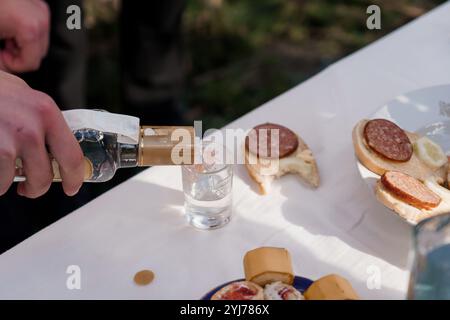 Treffen im Freien mit Vorspeisen und Spirituosen, die gegossen werden. Stockfoto