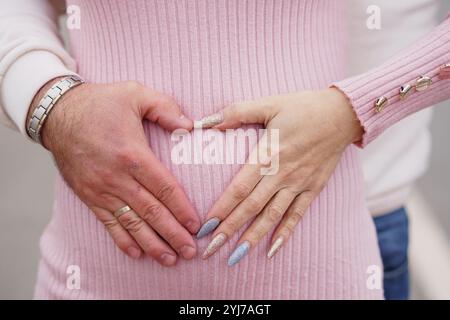 Erwartung der Liebe: Ein herzlicher Moment der Mutterschaft, aufgenommen in Soft Pastells. Stockfoto