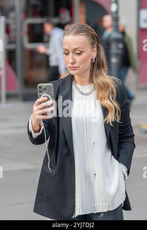 Porträt einer anspruchsvollen Frau mit europäischem Aussehen, 35-40 Jahre alt, mit einer Unschärfe einer modernen Stadt im Hintergrund. Stockfoto