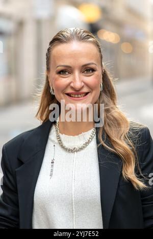 Porträt einer anspruchsvollen Frau mit europäischem Aussehen, 35-40 Jahre alt, mit einer Unschärfe einer modernen Stadt im Hintergrund. Stockfoto