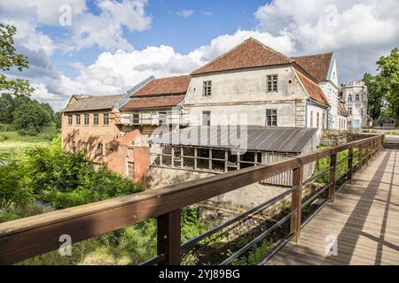 Kuldiga, Lettland - 3. Juli 2023: Haus mit Blick auf die Brücke des Aleksupiten-Wasserfalls im Sommer. Stockfoto