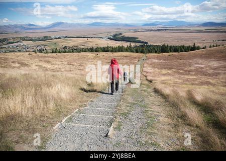 Wanderer gehen zurück auf dem Wanderweg vom Mount John Observatory. Stockfoto