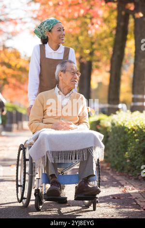 Seniorenmann im Rollstuhl und Betreuungshelfer Stockfoto