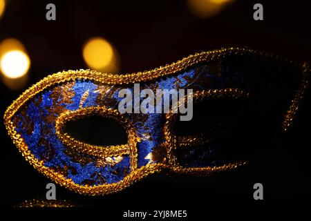 Schöne blaue Karnevalsmaske auf schwarzem Hintergrund, Nahaufnahme. Bokeh-Effekt Stockfoto