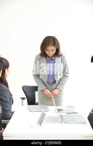 Büroangestellte mittleren Alters und Geschäftsleute verbeugen sich Stockfoto