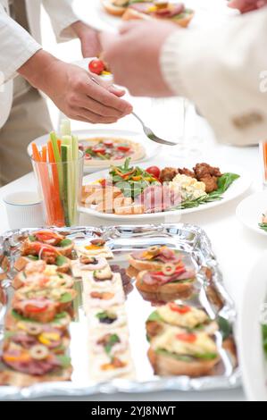 Leute essen Hors d'oeuvres auf einer Hausfeier Stockfoto