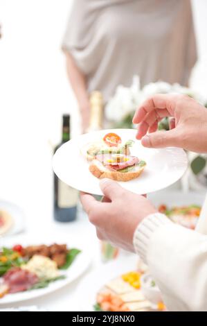 Leute essen Hors d'oeuvres auf einer Hausfeier Stockfoto