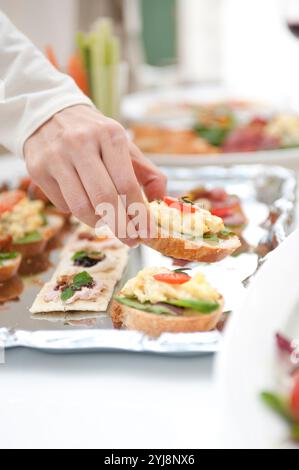 Leute essen Hors d'oeuvres auf einer Hausfeier Stockfoto